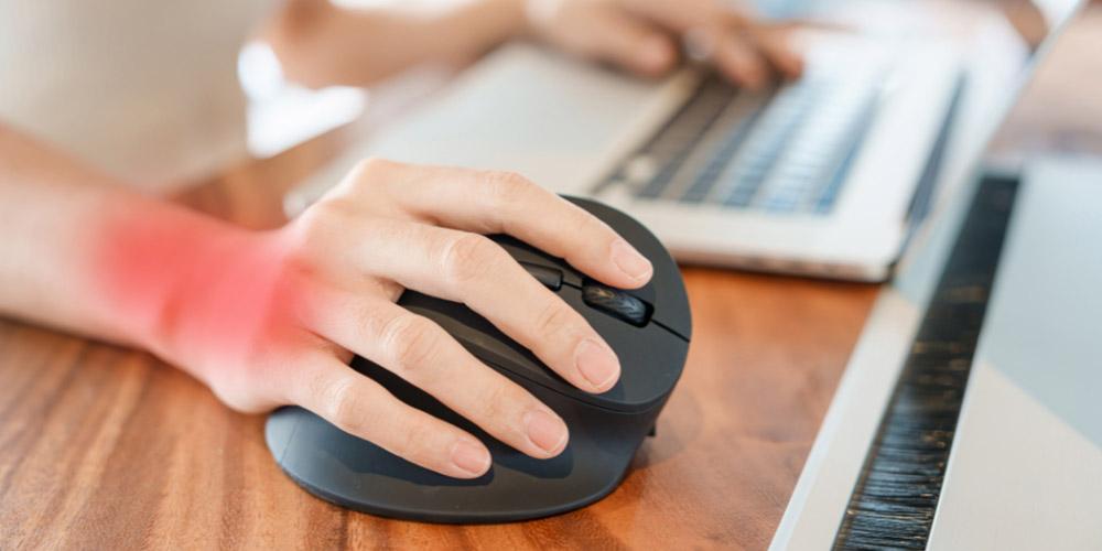 MedLife - mano con dolor por síndrome del túnel carpiano causado por el uso prolongado del mouse, ilustrando un problema de ergonomía