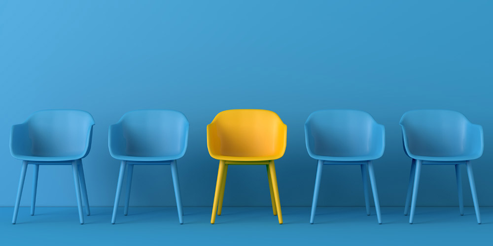 MedLife - una silla amarilla entre varias sillas azules simboliza la inclusión y el cambio ergonómico que impulsa la Ley Silla en los espacios laborales